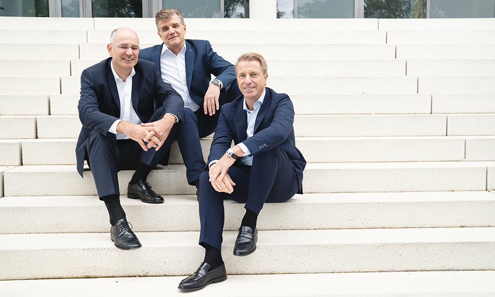 Die DAT Geschäftsführung vor dem DAT Gebäude in Ostfildern. Von links nach rechts: Dr. Thilo Wagner, Jens Nietzschmann, Helmut Eifert